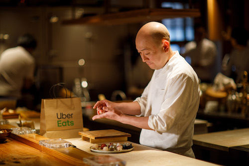 Sushi chef preparing an Uber Eats delivery.